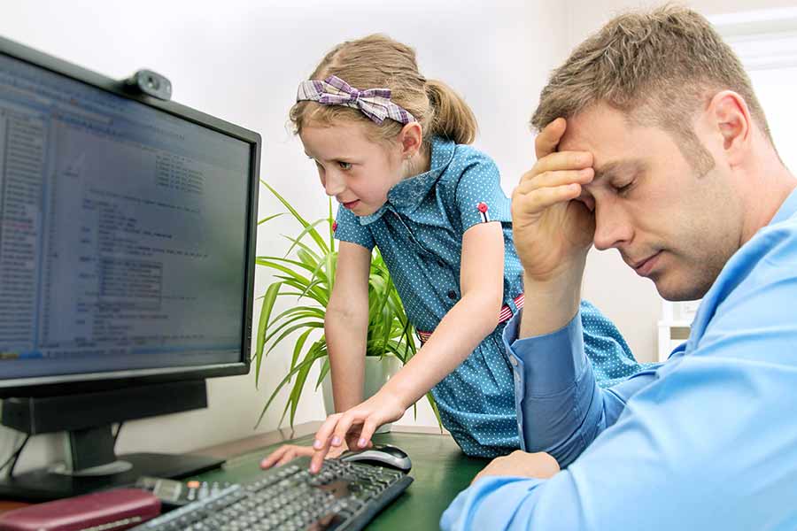 Padre de familia tratando de hacer home office mientras su hija lo distrae