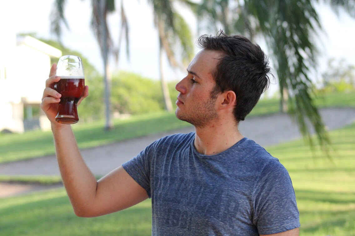 Miguel Márquez examinando un vaso de cerveza artesanal.