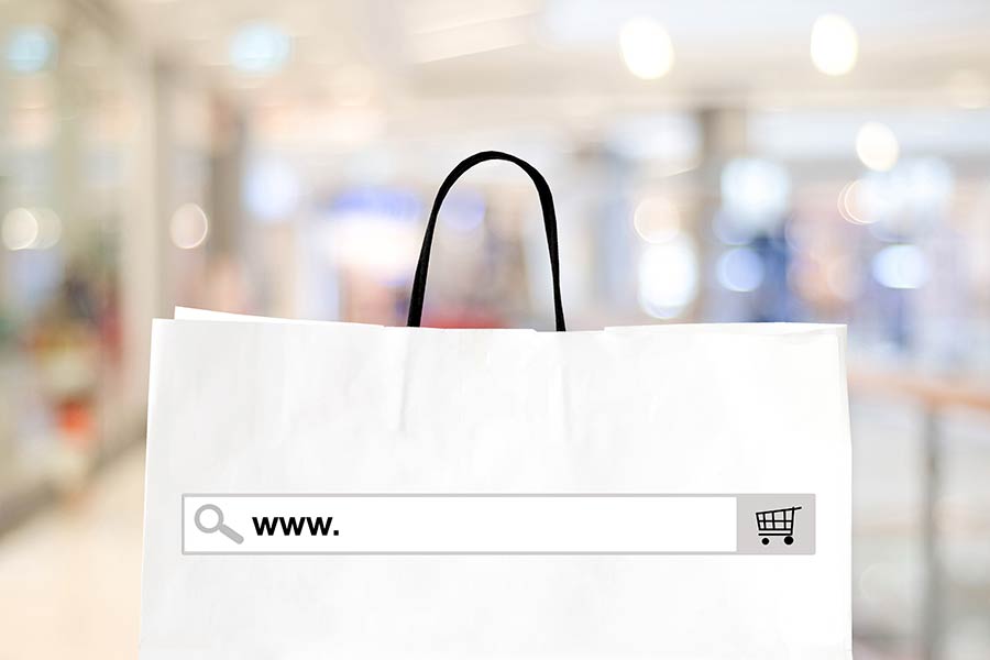 Concepto de sitio web de negocio en línea, con el buscador de internet y las siglas www sobre una bolsa de compras